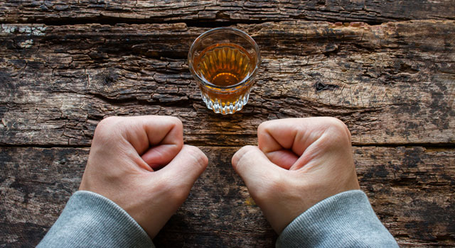 clenched fists next to alcohol shot