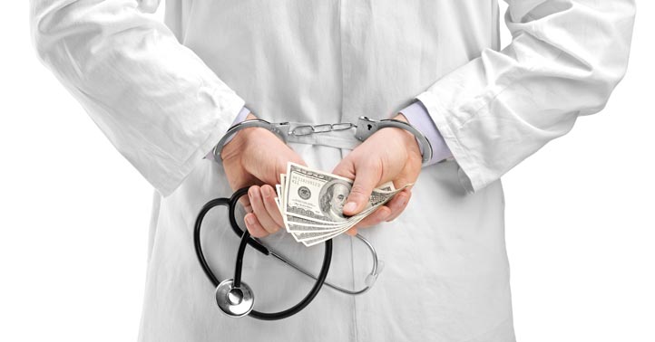 doctor in handcuffs holding money